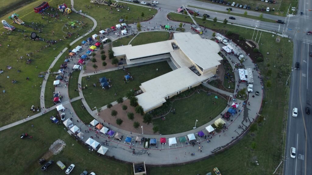 Aerial view of a circular building surrounded by festival tents in Royse City, TX.
